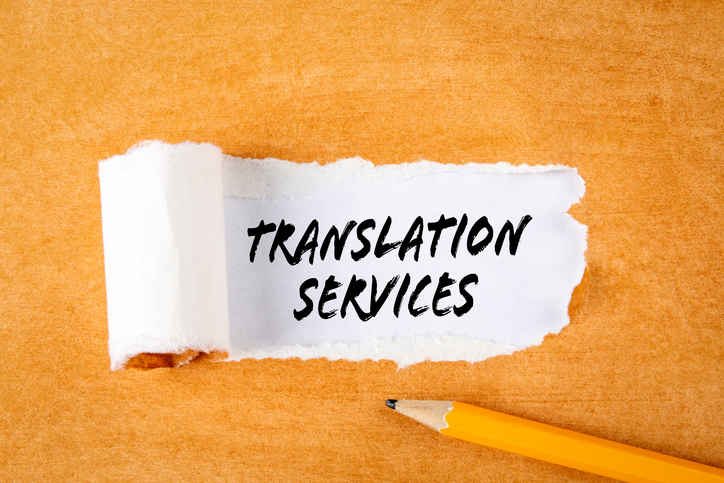 Translation Services. Business concepts. Pencil on an orange cardboard background.